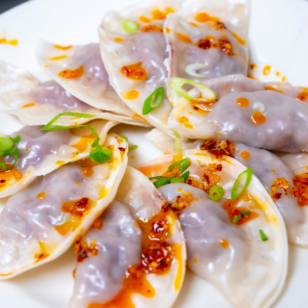 Image of ginger soy dumplings with chili crisp and scallions. 