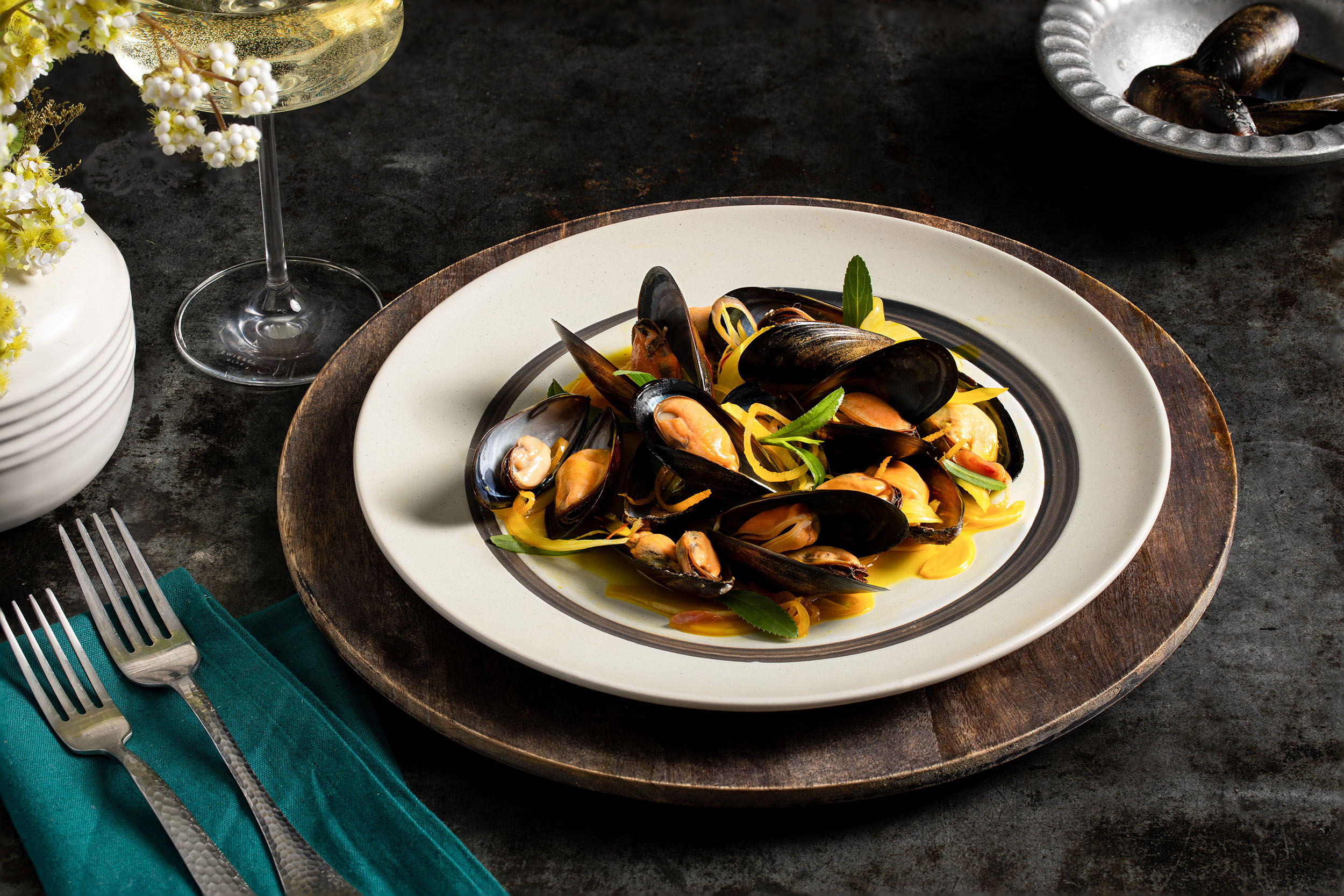 A white plate Mussels with Saffron and Citrus